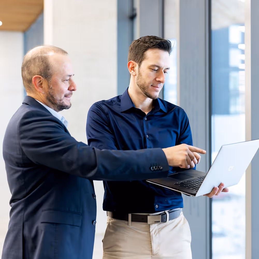 Two engineers, Alejandro Luy and Yilmaz Luy looking at their laptop potential engineering.