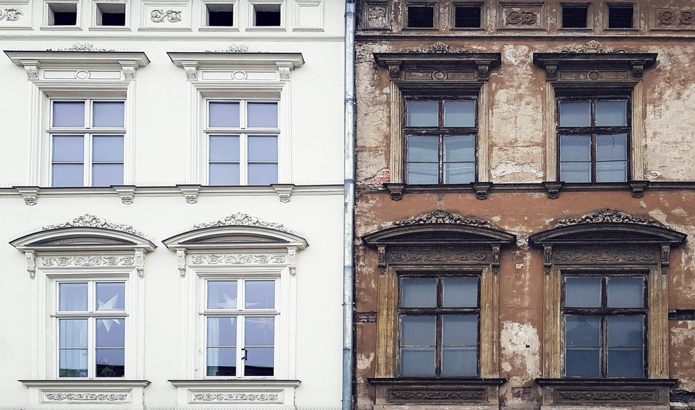 Side-by-side comparison of two building facades with identical window designs, one freshly painted white and the other weathered and peeling.