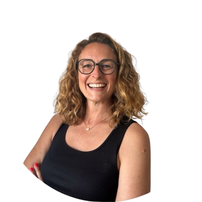 Smiling woman with curly blonde hair, wearing glasses, a black sleeveless top, and a small necklace.