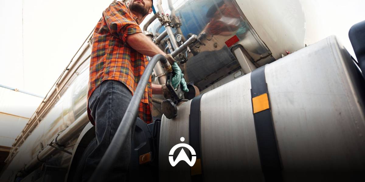 พนักงานขับรถบรรทุกกำลังเติมน้ำมันลงถังน้ำมันขนาดใหญ่