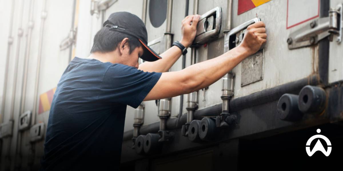 พนักงานขับรถชายกำลังปิดประตูตู้ รถขนส่งแช่เย็น