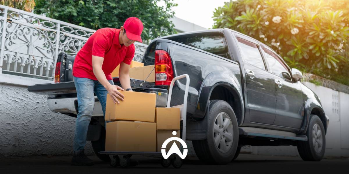 พนักงานกำลังนำพัสดุ-สินค้าลงจากท้ายรถกระบะขนส่ง