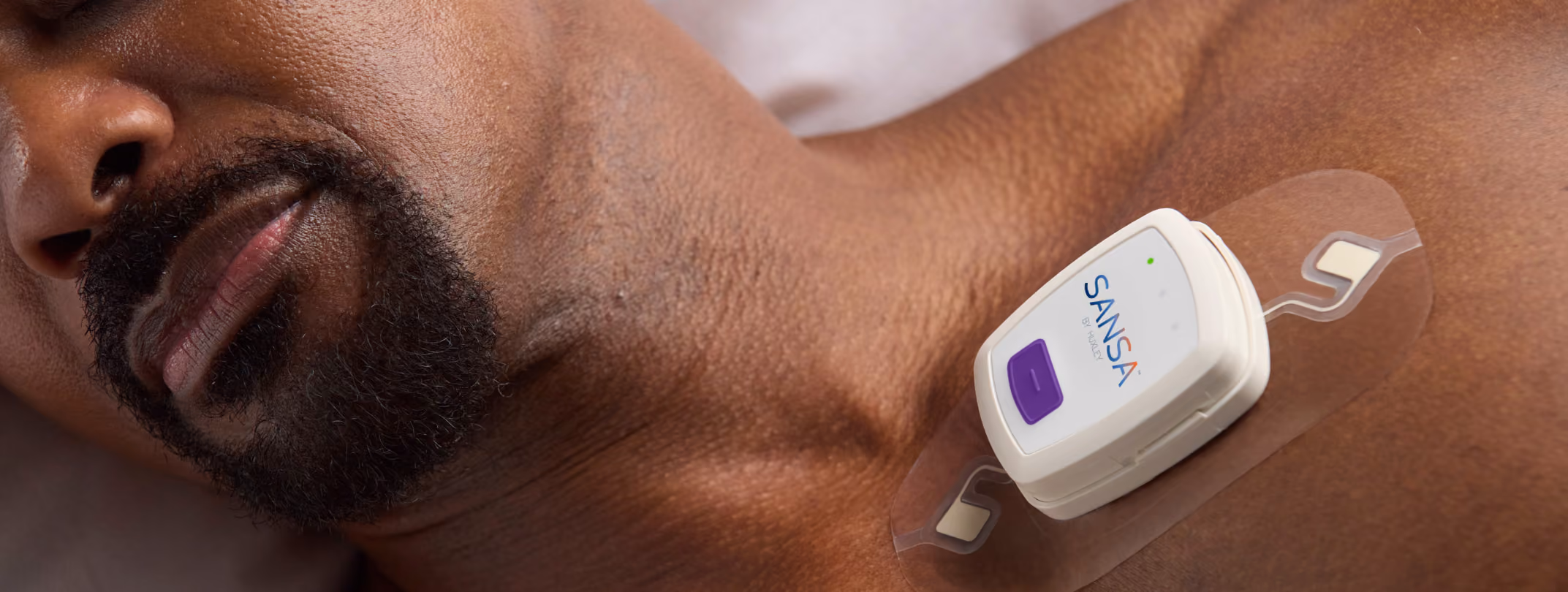 Man lying down with a SANSA home sleep test patch worn on his upper chest