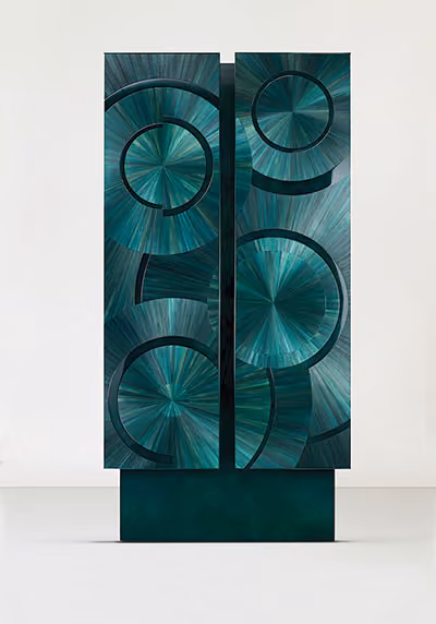 Tall emerald green wardrobe embossed with circle pattern.