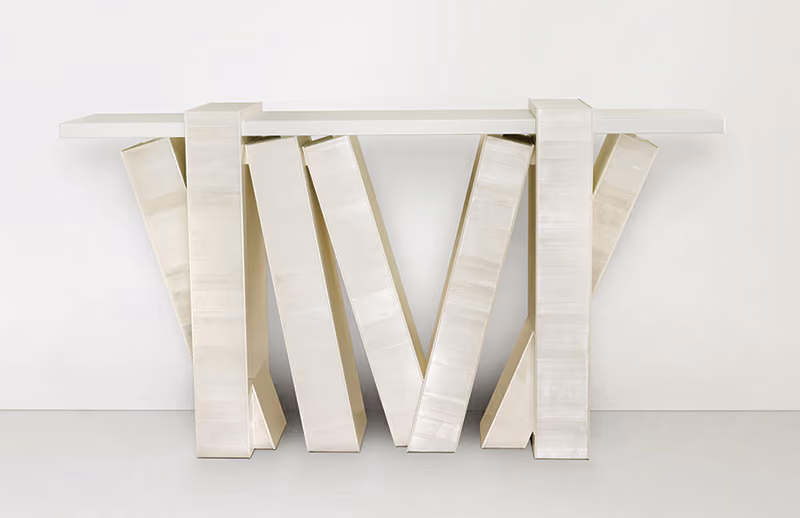 Narrow white table with branching sculptural legs.
