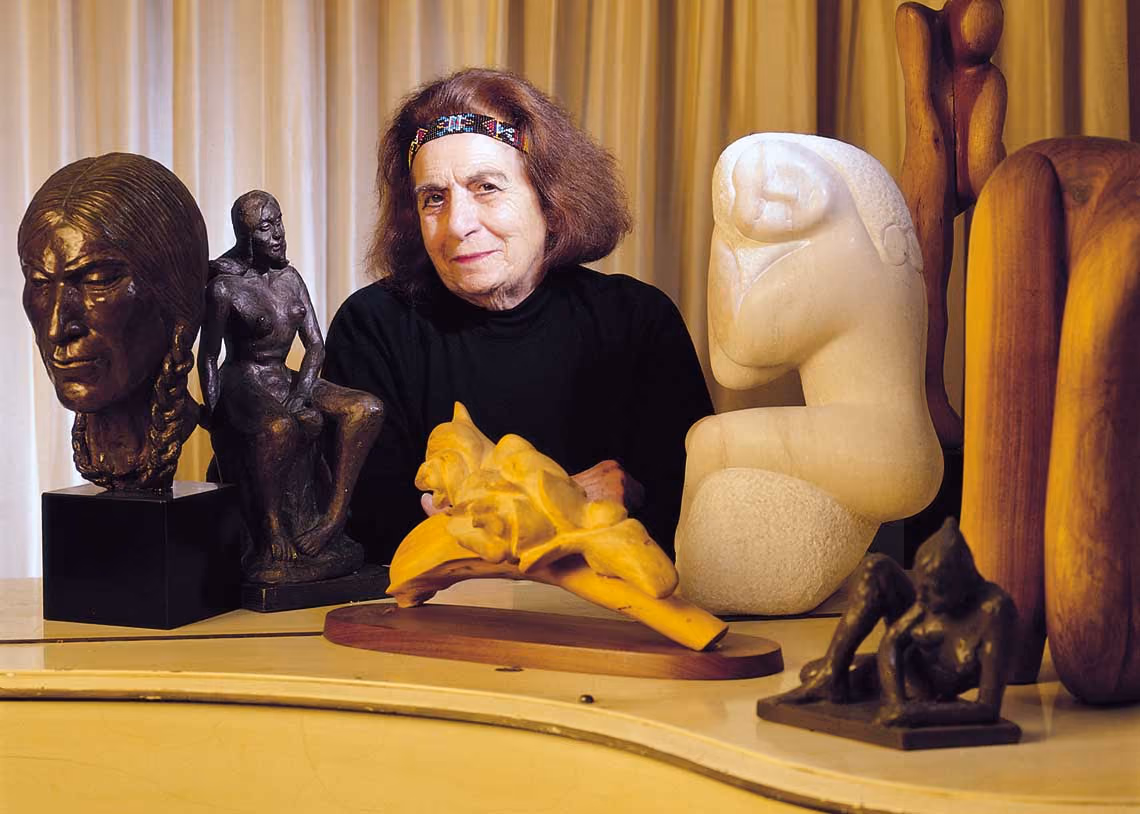 In this undated photo, Terri Cosma Boor sits surrounded by sculptures she created. Many of her works are displayed throughout the campuses. (File)