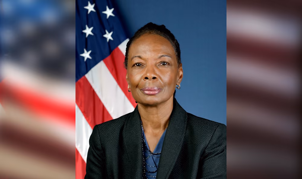 A studio portrait of an African American woman, Gloria Shepherd, as she poses in front of the U.S. flag