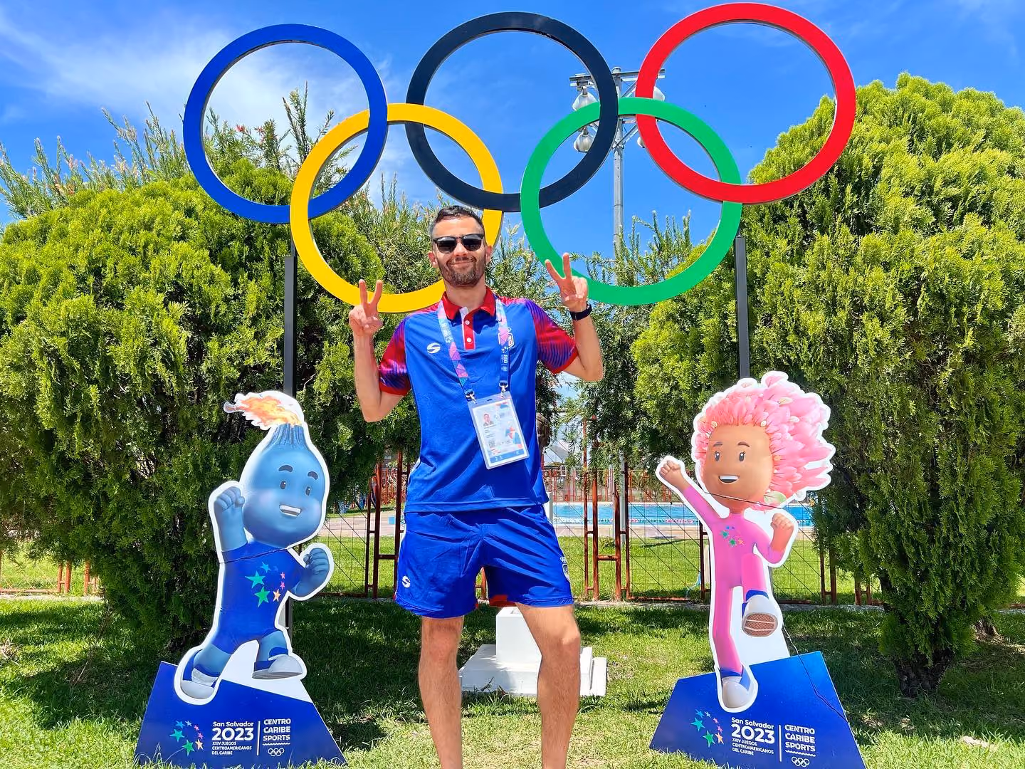 A photo of UAlbany alum Ricardo Estremera in front of the Olympic rings.