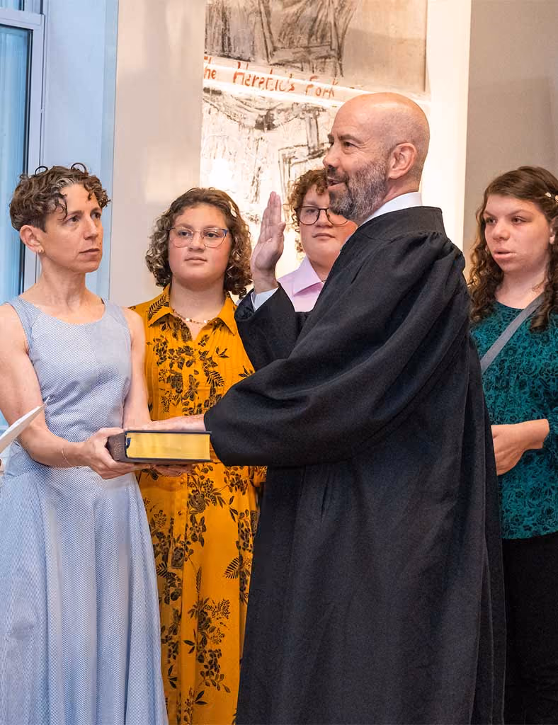 Seth Marnin, in judicial robes, is sworn in by Hon. Rosalyn H. Richter (Ret.) as family members look on.