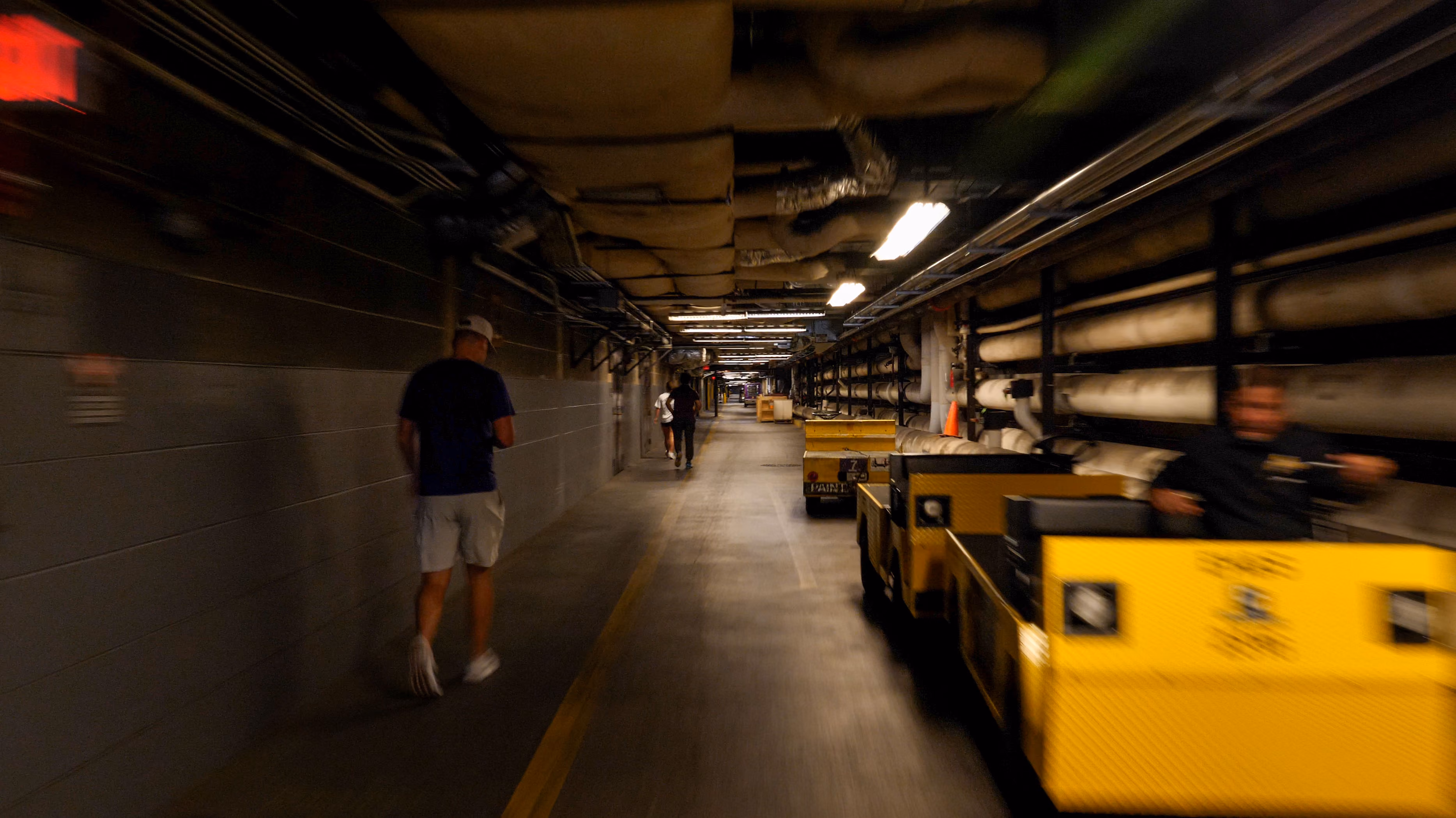 A present day color photograph showing pedestrians walking on one side of the tunnels while electric carts line the other side.
