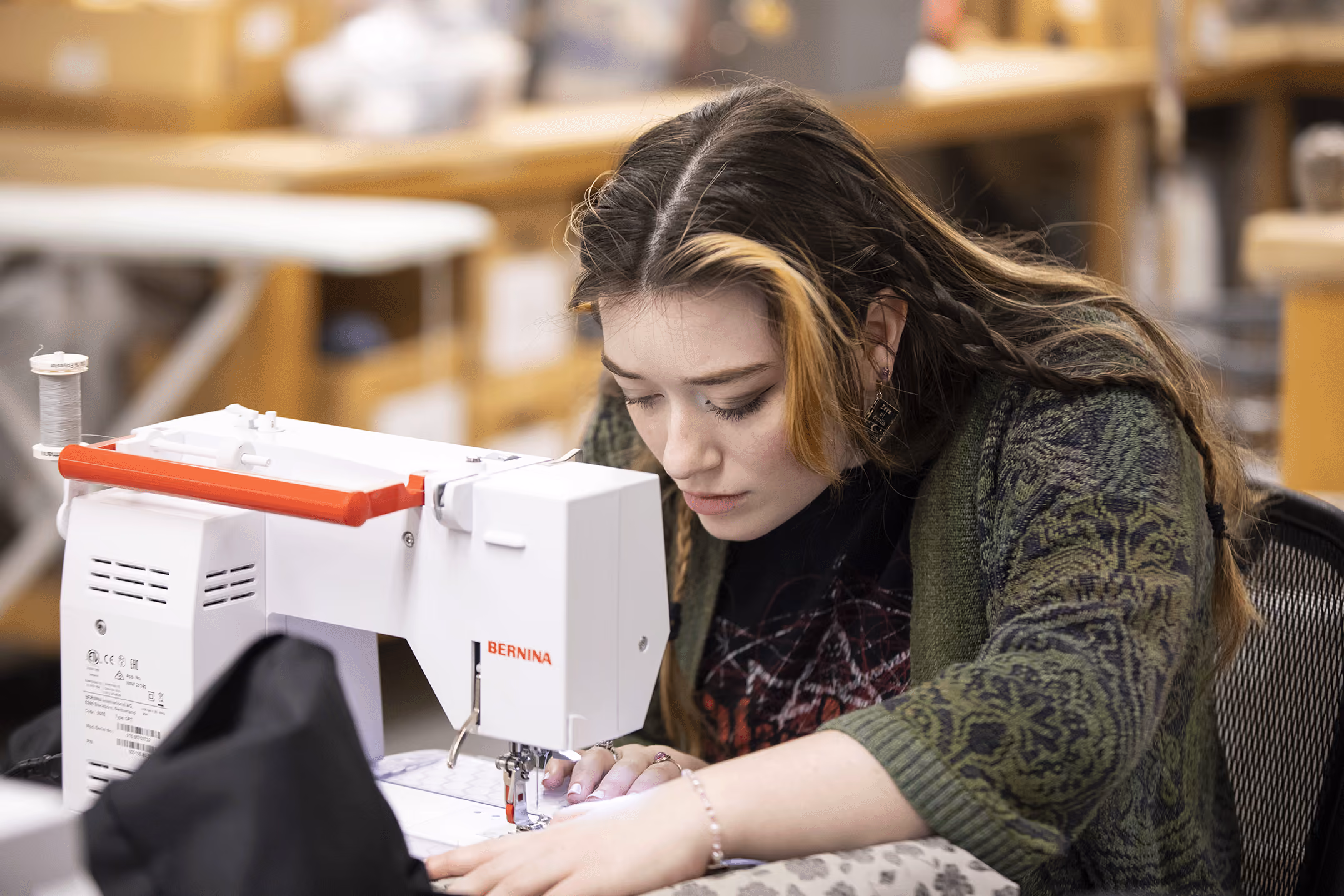 A female student using a sewing machine.