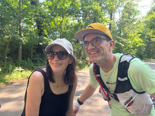 A man dressed in running gear and a woman pose together as friends