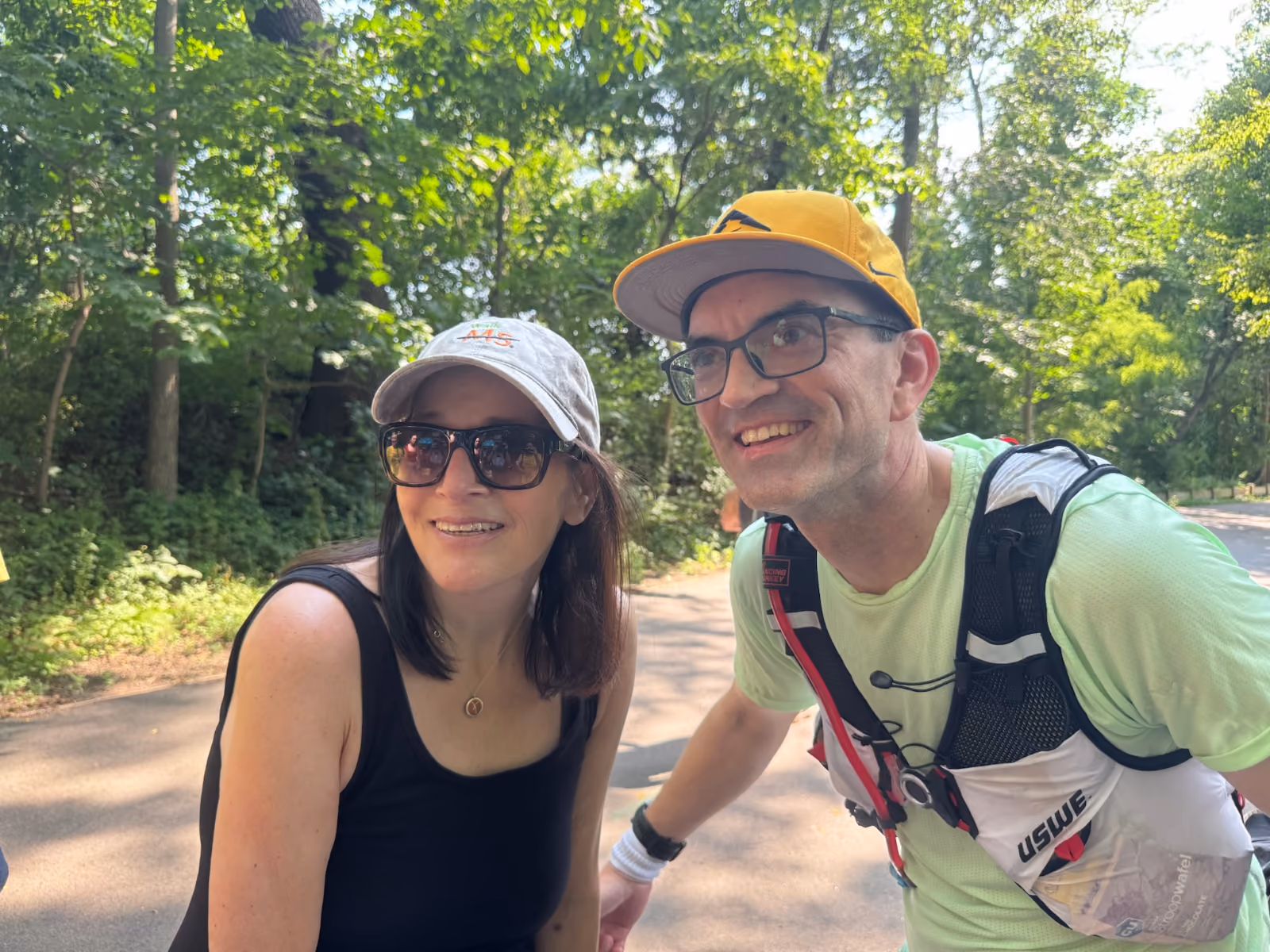 A man dressed in running gear and a woman pose together as friends