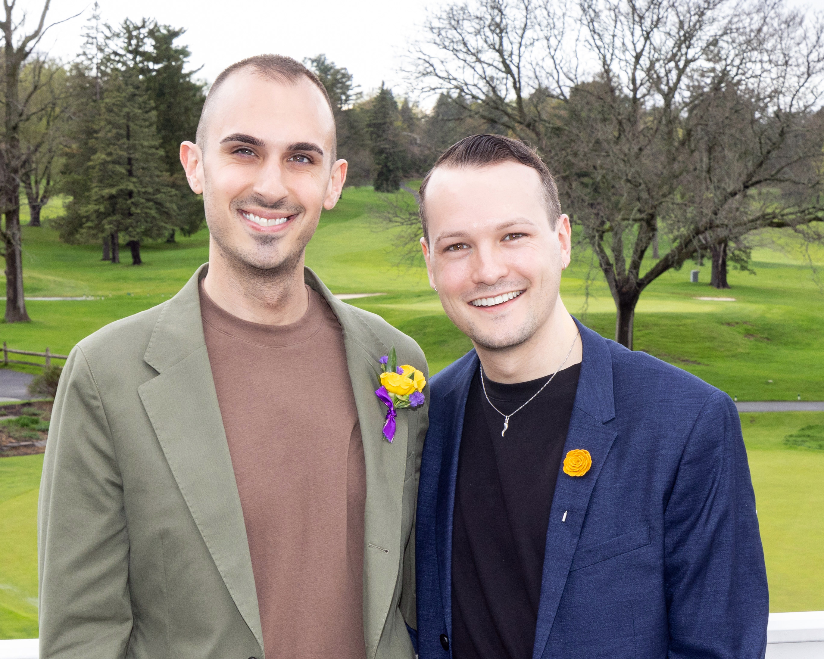 Two people pose for a photo outside.