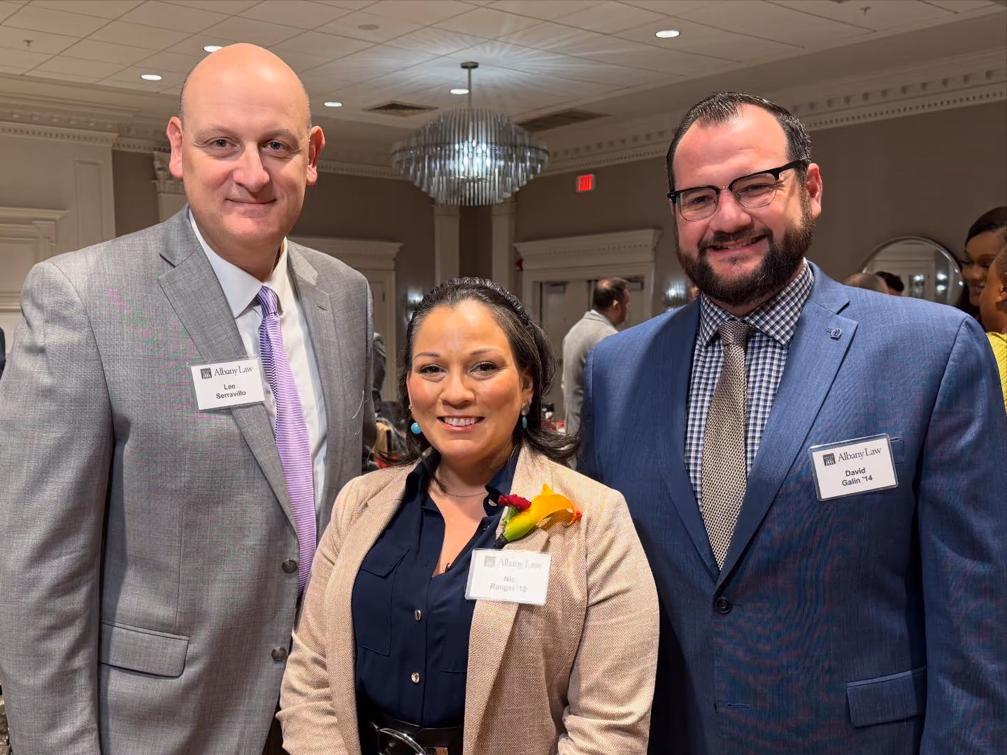 Three people pose for a photo at an event.