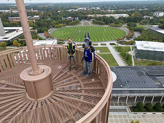 Brian and Damien the mascot on the top of the Carillon in the basket.