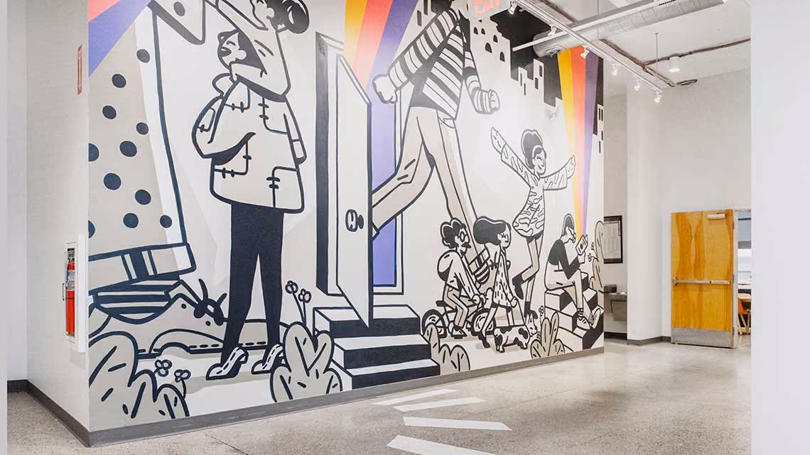 A wall with an illustrated mural at the Duolingo office.