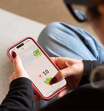 A close up of Adele using the Duolingo app on her phone.