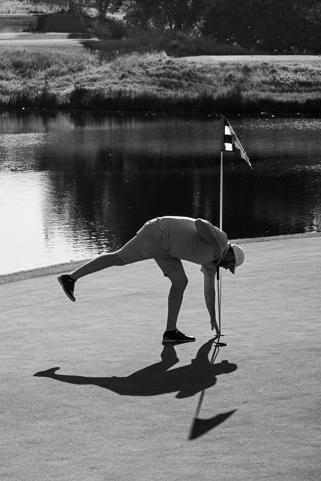 Golfer picking up ball out of hole