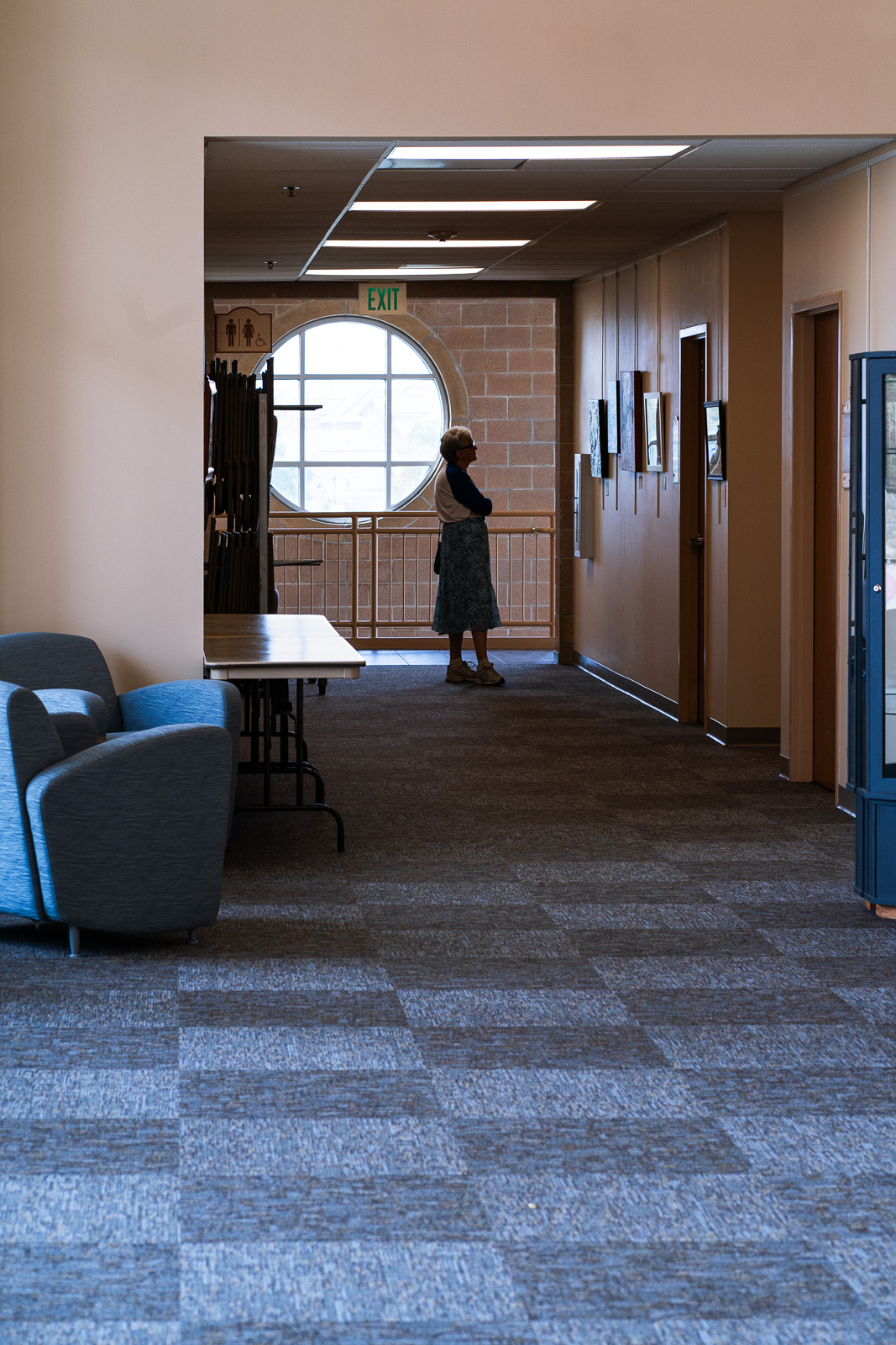 Woman in a hallway looking at art on the wall