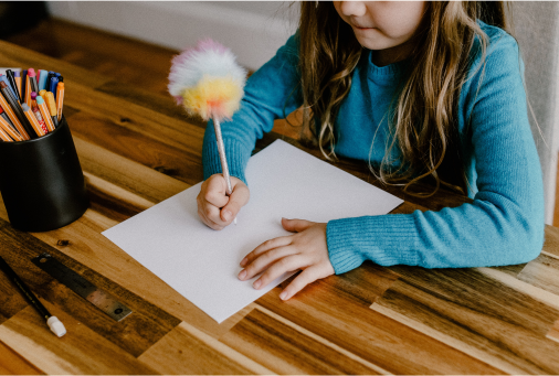 A child drawing at a table during an activity