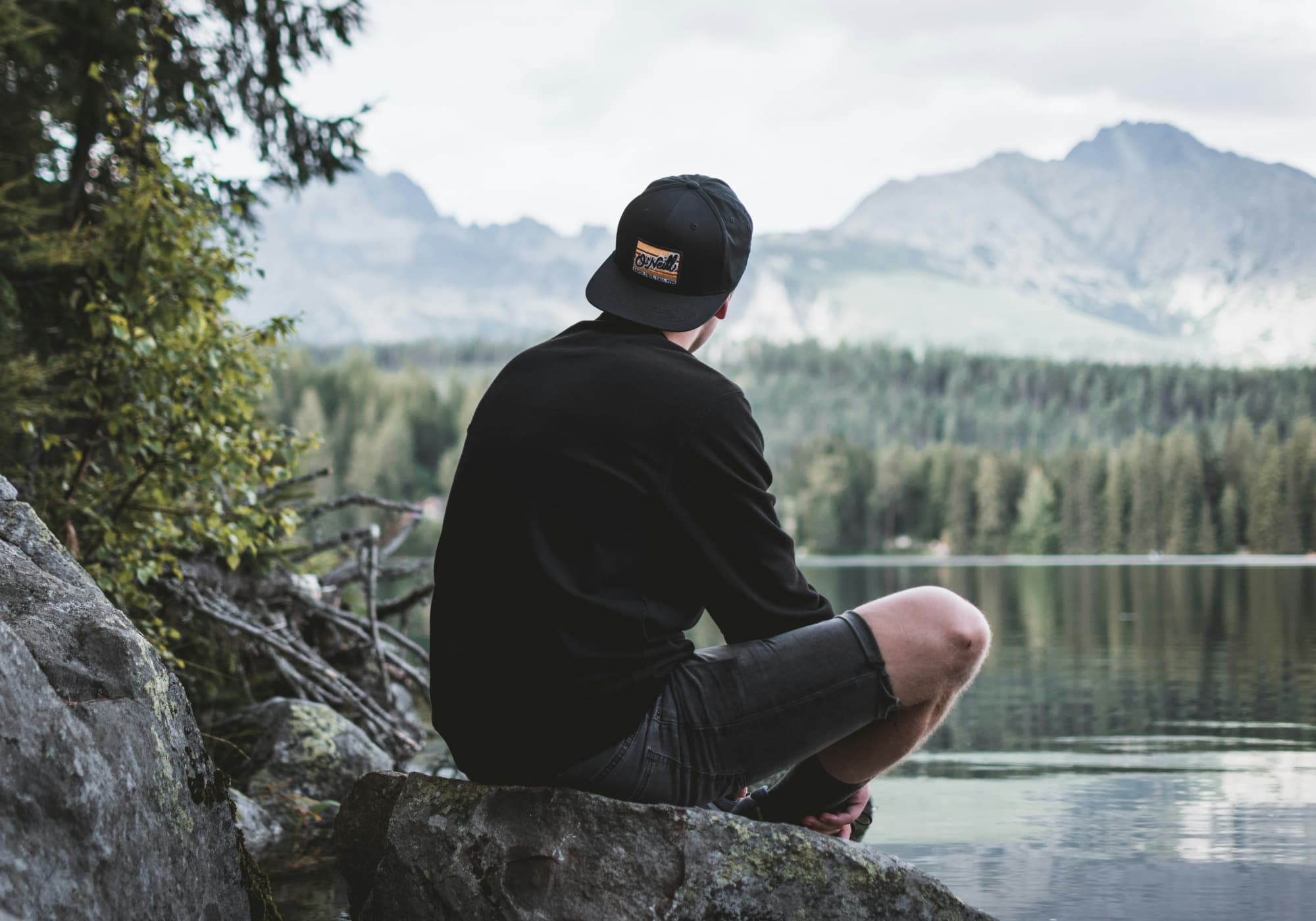 Man sitting by waters edge