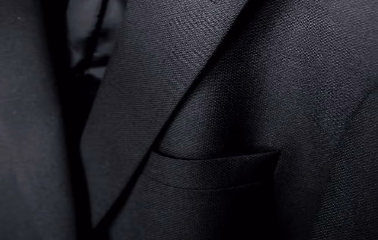 A close up of a black suit and tie.
