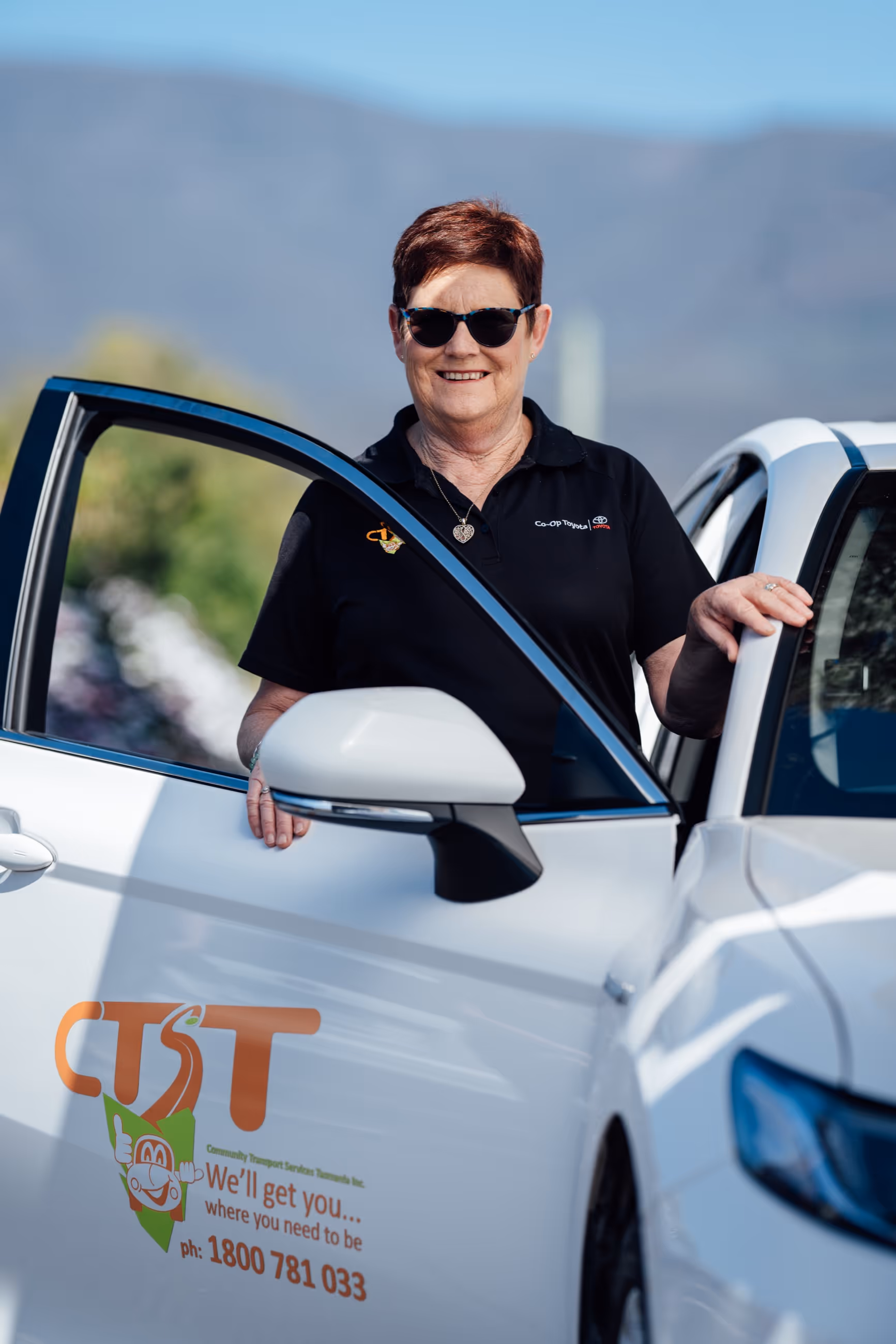 A CTST staff member standing behind the door of their vehicle