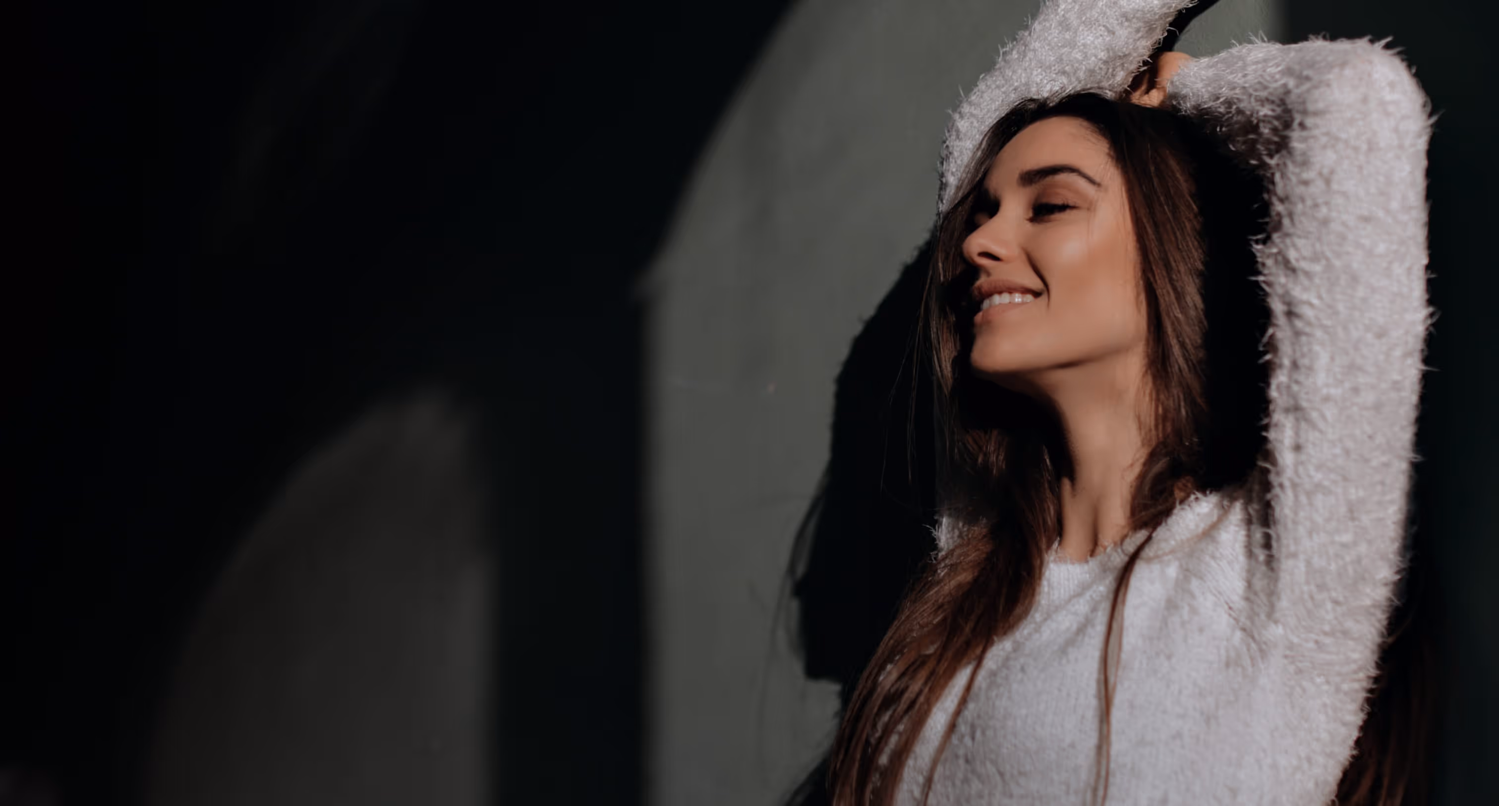 Woman leaning against a wall, smiling