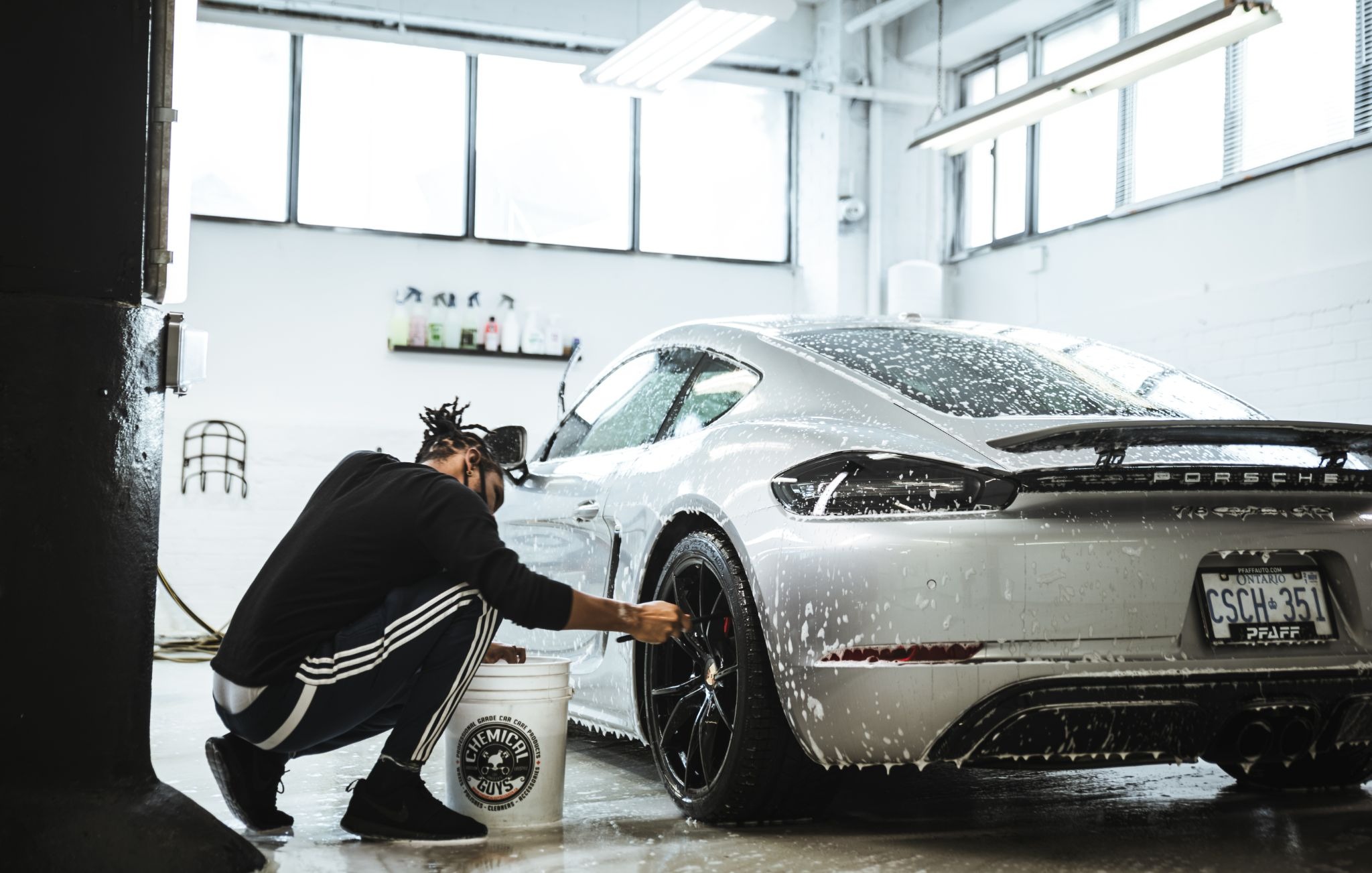 Car detailing Toronto — detailer washing Porsche rims at a professional Toronto auto detailing studio.