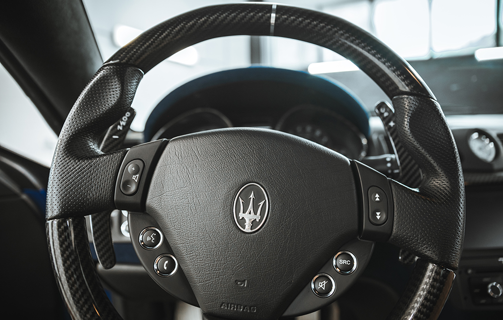 Close-up of a luxury Maserati steering wheel after professional interior car detailing near me service by ALPHASHINE. The leather and carbon fiber surfaces appear deeply cleaned and conditioned, showcasing premium car interior cleaning Toronto results.