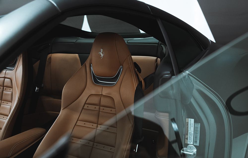 Detailed shot of tan Ferrari leather seats showing refined finish and cleanliness achieved through premium interior car detailing services in Toronto. Perfect representation of car interior cleaning Toronto for high-end sports cars.