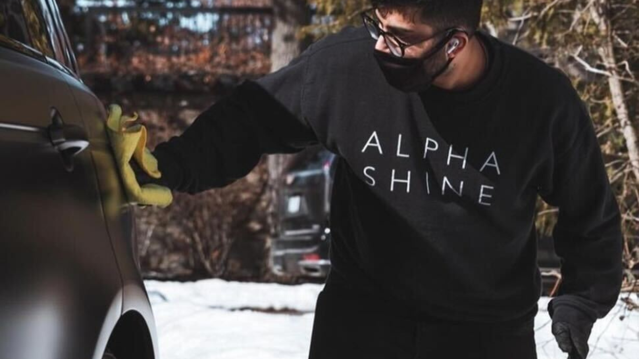 An ALPHASHINE technician performing winter car detailing Toronto services, wiping down a vehicle exterior with a microfiber cloth to remove salt and buildup.