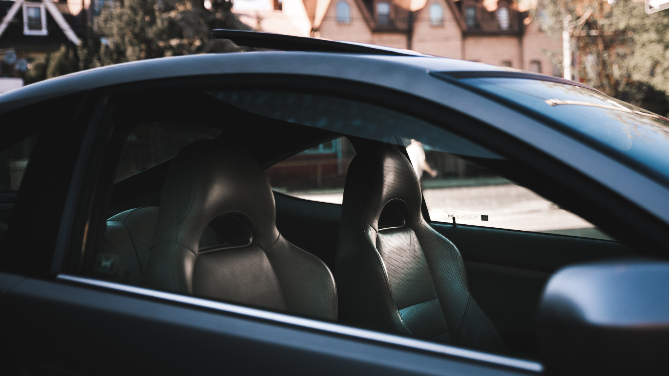 Clean car interior seats viewed through the side window after professional interior detailing, showcasing a well maintained and comfortable driving space.