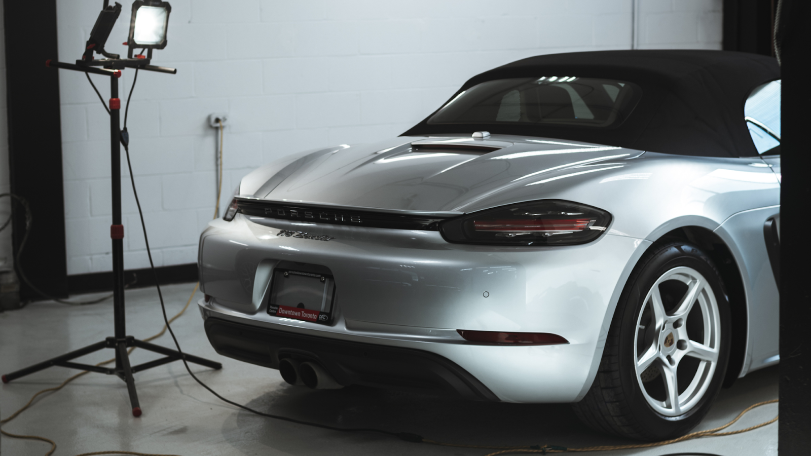 Silver Porsche convertible inside detailing studio after car wash Toronto and exterior detailing, showcasing polished paint and refined finish.
