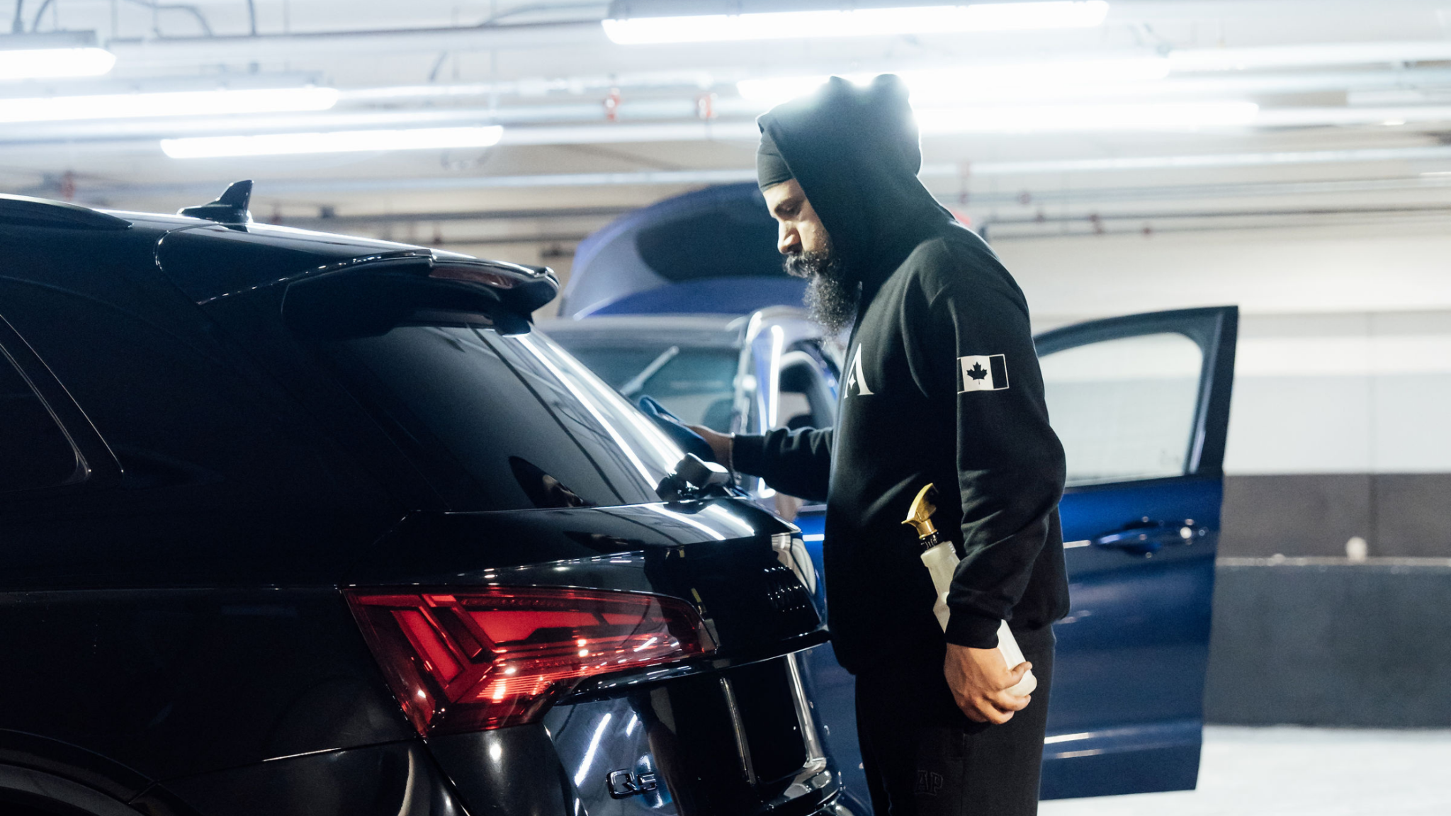 Detailer inspecting and wiping vehicle surface at ALPHASHINE Toronto, professional car detailing service