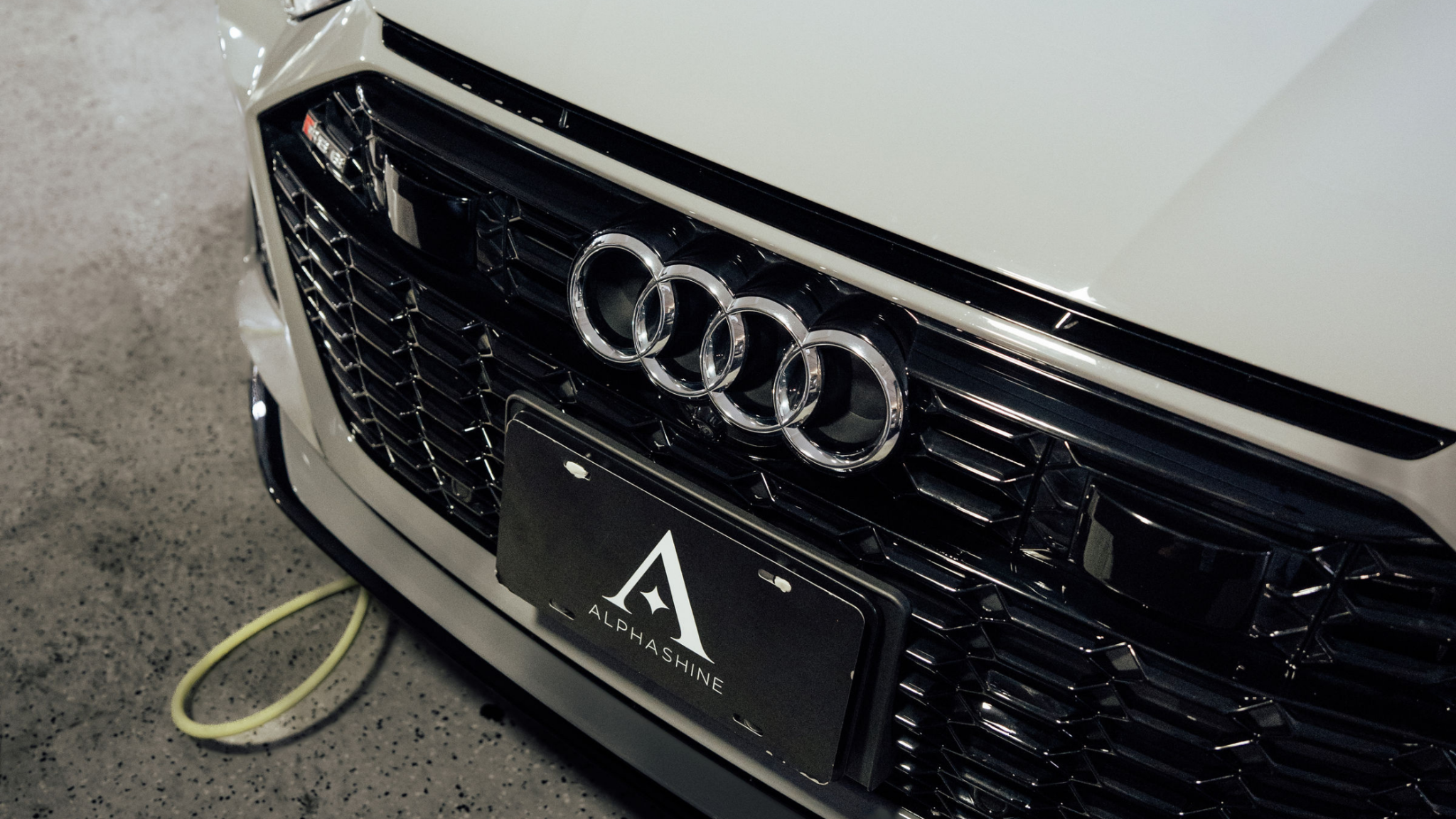 Audi front grille close up with ALPHASHINE plate, premium car detailing in Toronto