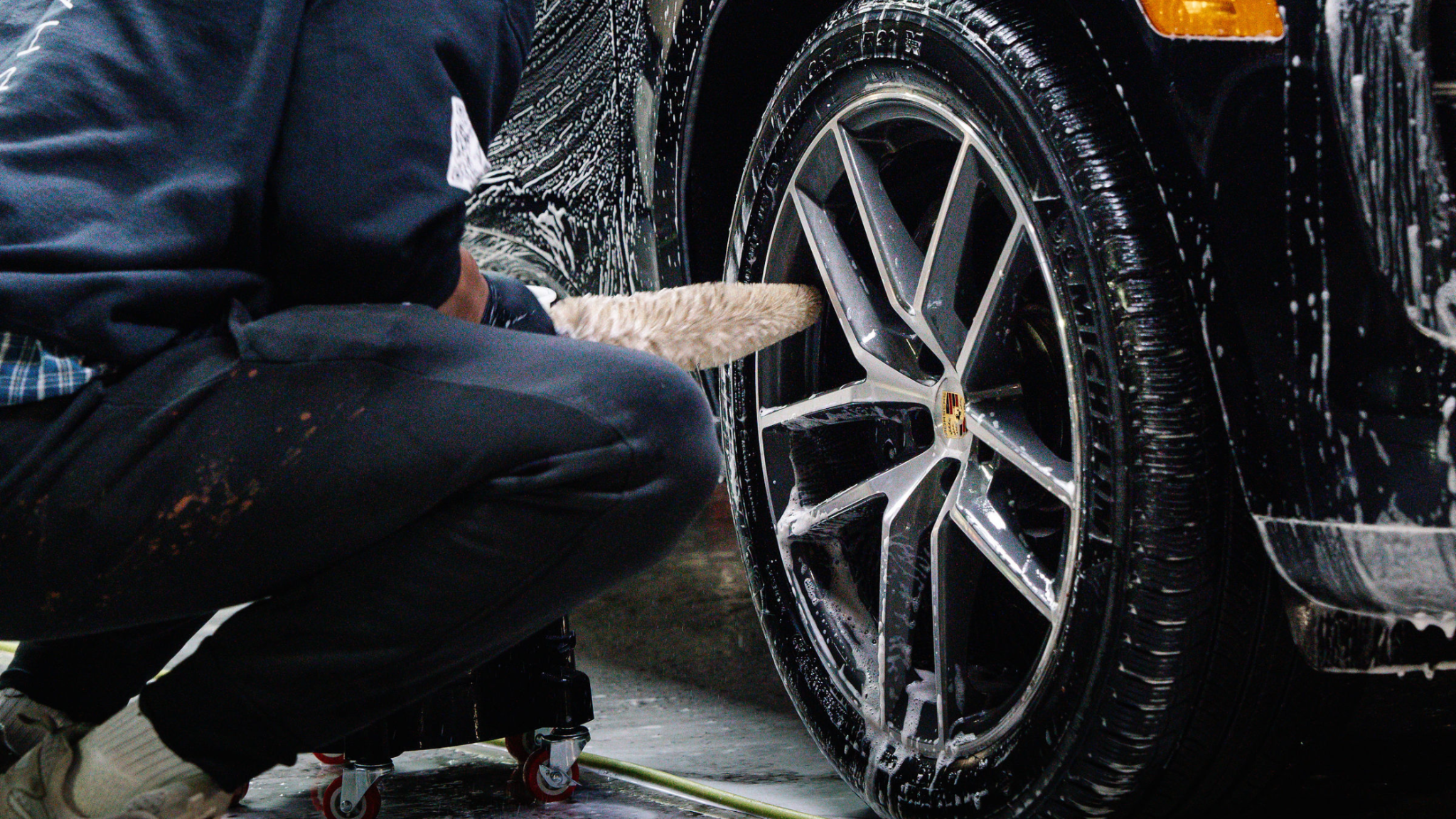 Wheel cleaning in progress with detailing brush and foam at ALPHASHINE Toronto, professional exterior car detailing