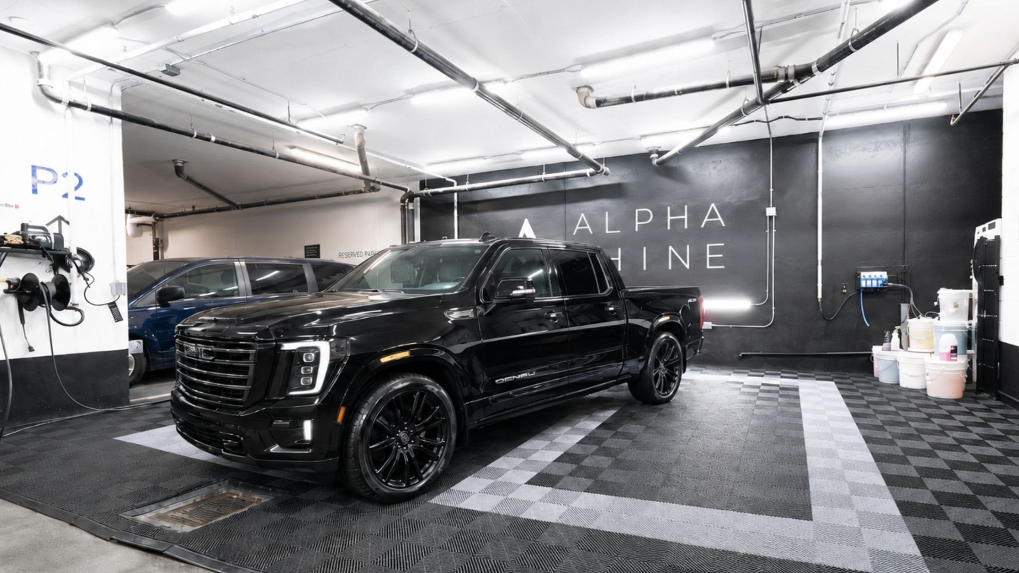 A black pickup truck parked in ALPHASHINE's King West facility after a pick up truck detail