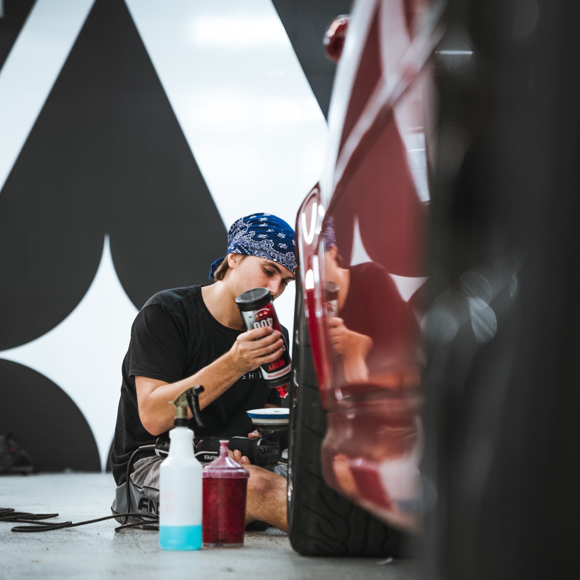 An Alphashine employee in the paint correction process on a car.