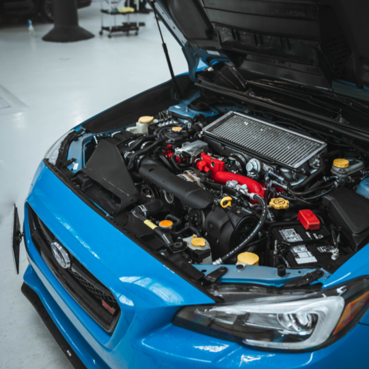 An open car hood showing a cleaned engine bay as performed by Alphashine.