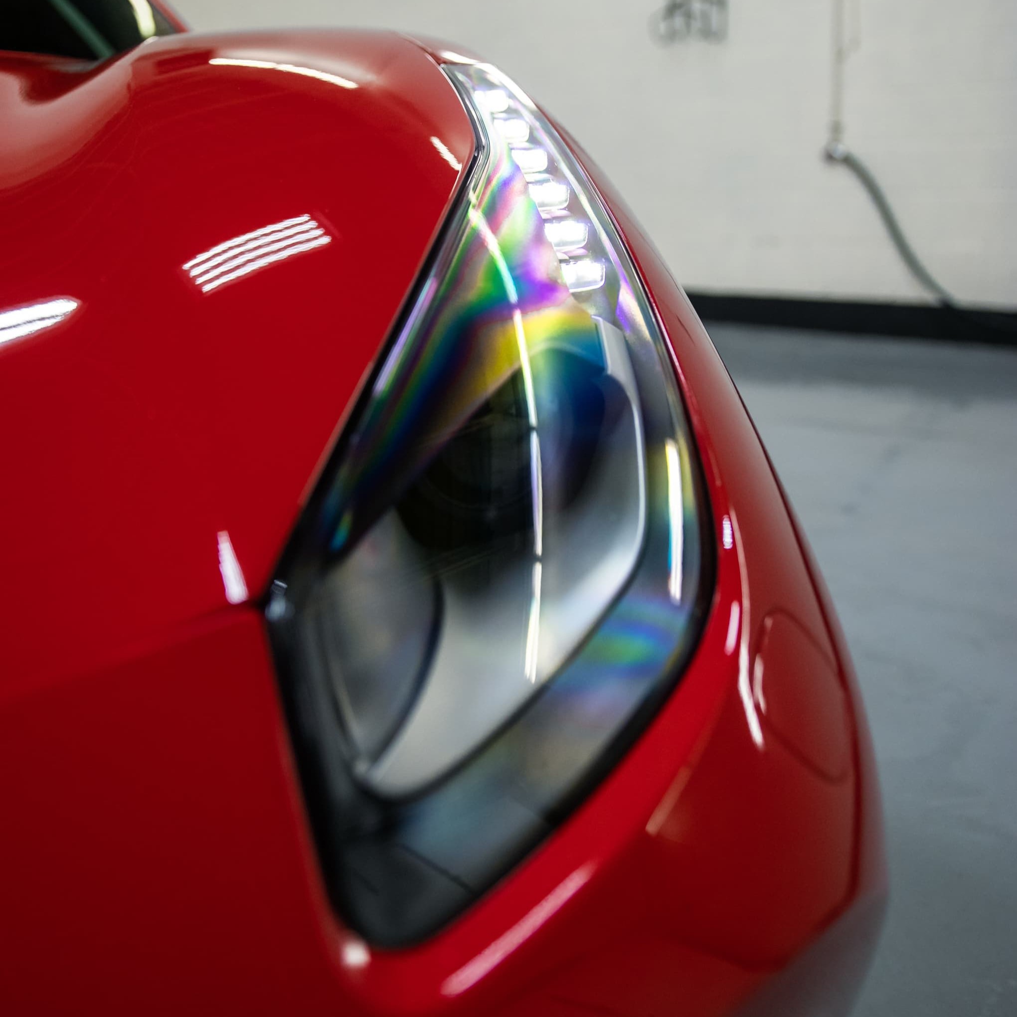 Headlight restoration done by Alphashine on a red car.