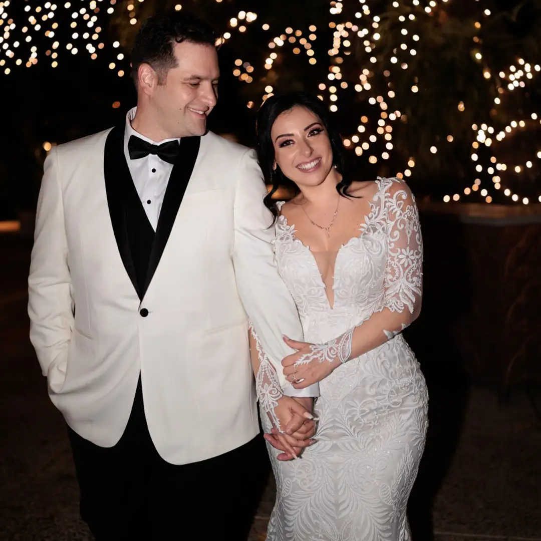 Bride in a stunning designer dress with her veil blowing in the wind.