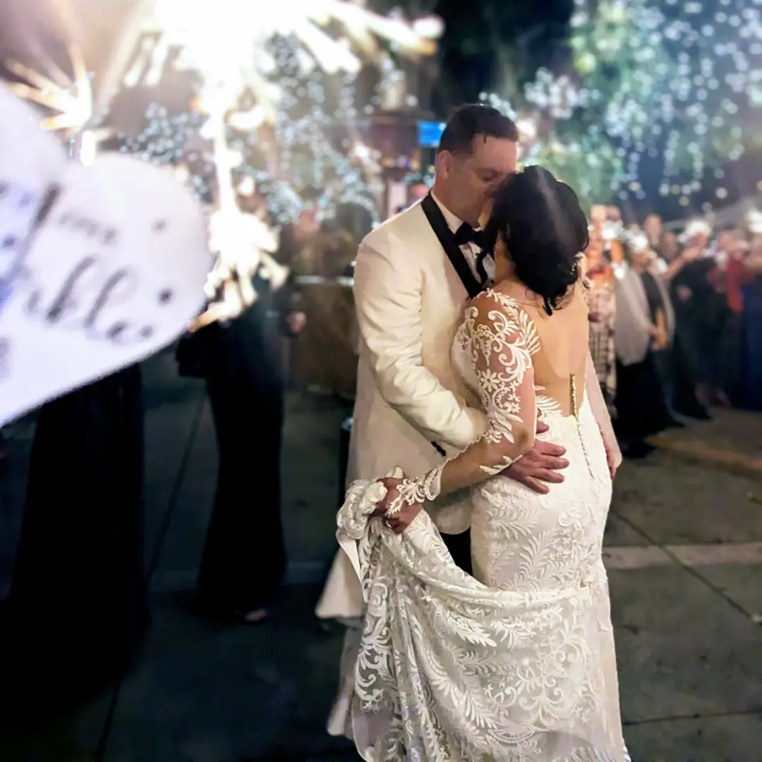 Bride in a stunning designer dress with her veil blowing in the wind.