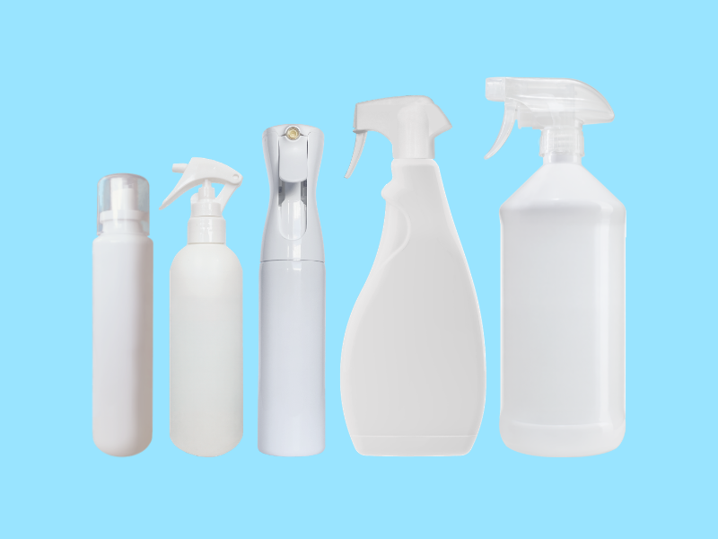 Cinq bouteilles de pulvérisation blanches alignées sur fond bleu clair.