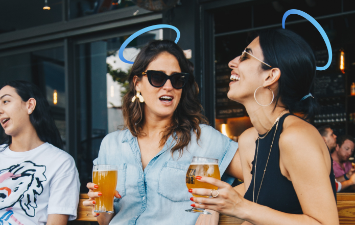 Femmes qui rigolent dans un bar avec une bière