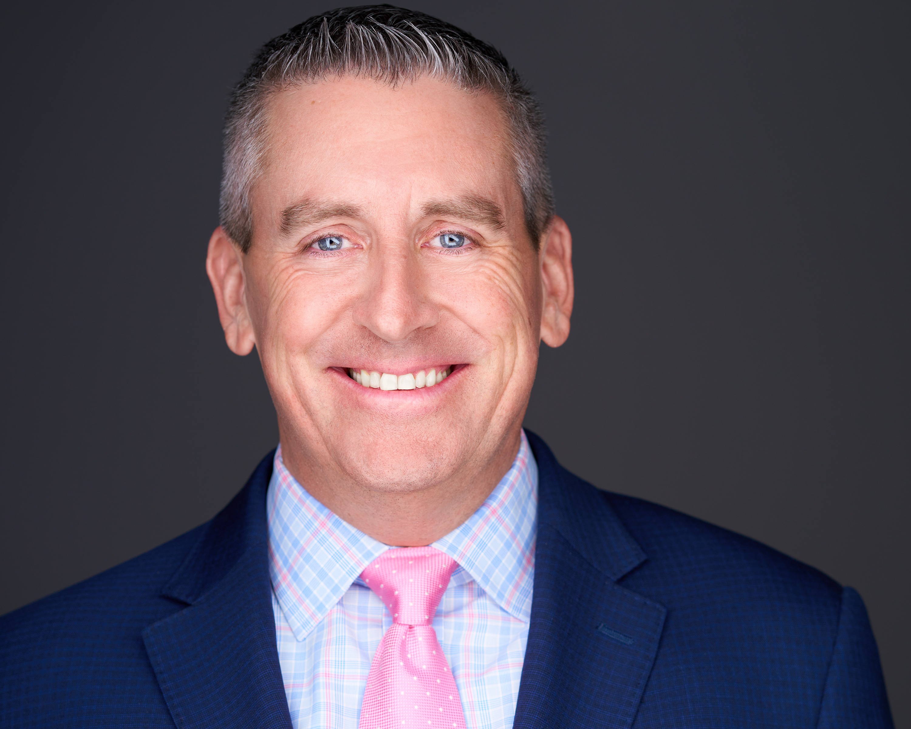 Executive headshot of man in pink tie, professional portrait