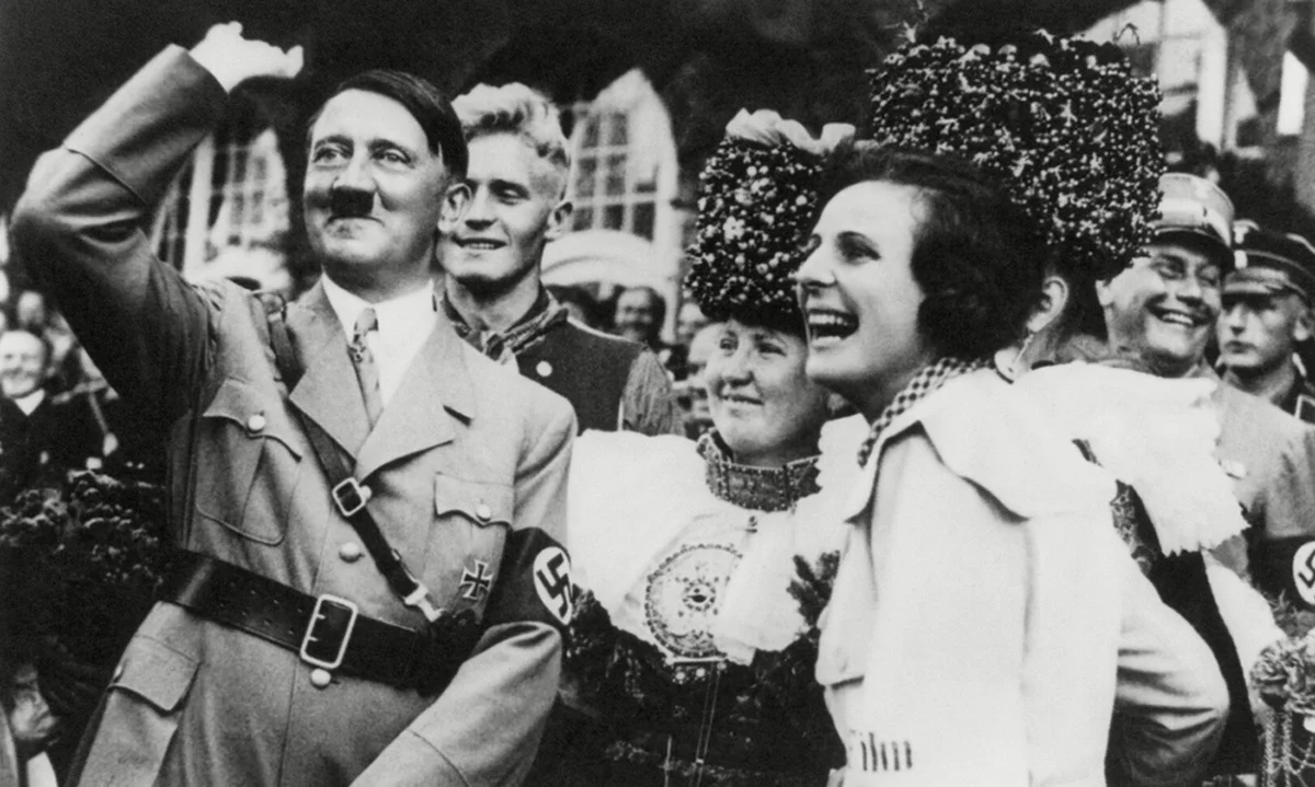 Leni Riefenstahl (derecha) con Adolf Hitler durante el rodaje de El triunfo de la voluntad, 1934. Imágenes de Olympia aún utilizadas en la publicidad contemporánea del COI. El Comité Olímpico Internacional promociona los Juegos con un corto que se nutre am