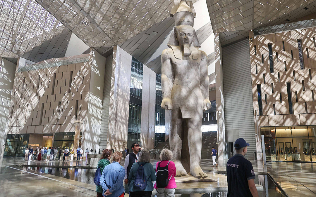 Visitors at the Grand Egyptian Museum stand before the colossal statue of Ramses II in the main atrium. Photo: © pa/dpa