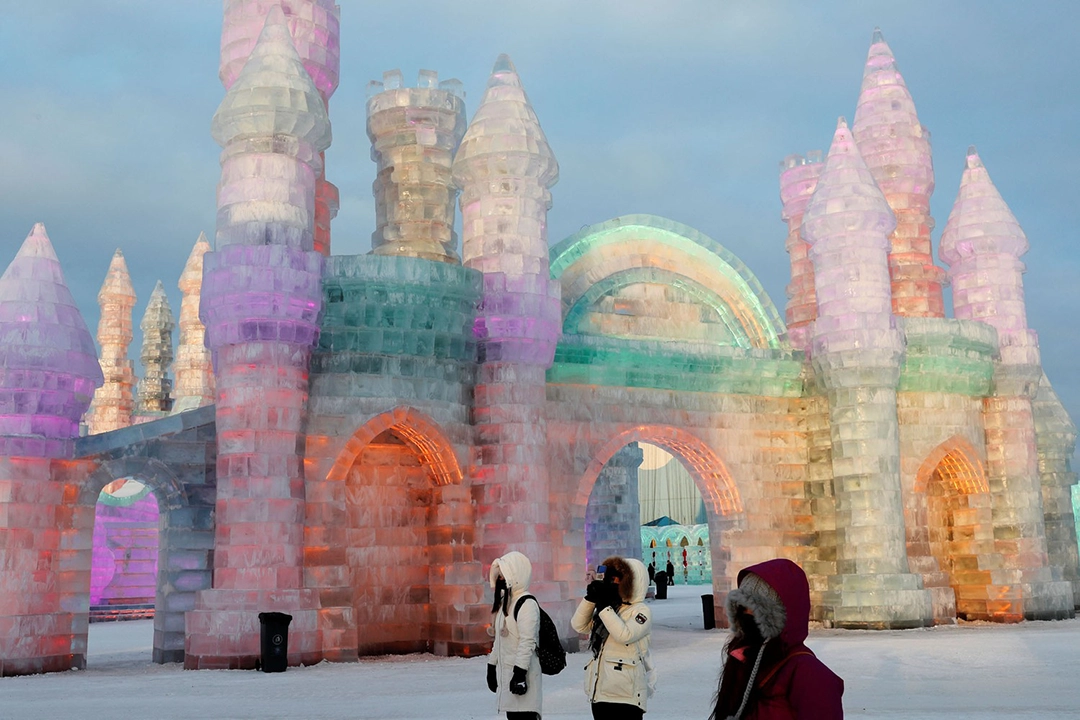 Visitantes posan frente a esculturas de hielo iluminadas con luces de colores, 4 de enero de 2019. The Atlantic.